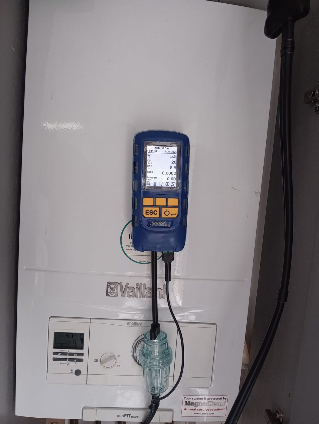 Gas Safe engineer carrying out a landlord gas safety certificate (CP12) check on a Vaillant boiler with a flue gas analyser in Dagenham, East London